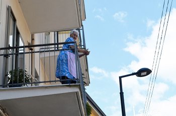 Una signora ascolta il concerto dal balcone