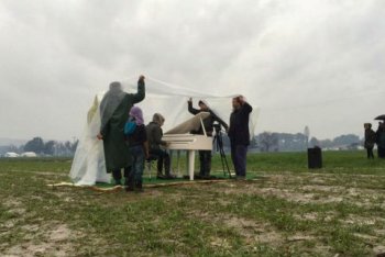 Nour Alkhzam suona il pianoforte bianco portato da Ai WeiWei nel campo profughi di Idomeni